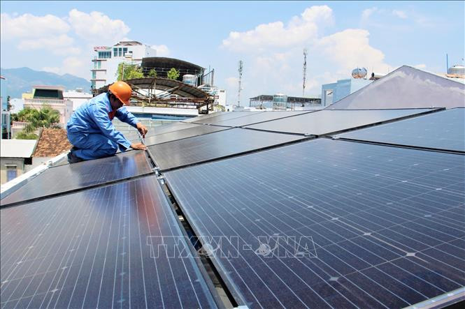 Lắp đặt tấm pin mặt trời trên mái nhà tại một hộ dân Ảnh: Tiên Minh - TTXVN