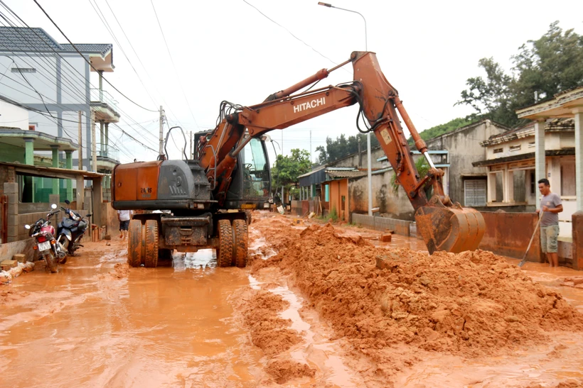 Do lượng cát đỏ quá lớn ngập đường Lạc Long Quân nên việc di chuyển, dọn dẹp cát đỏ rất khó khăn. Ảnh: Nguyễn Thanh - TTXVN
