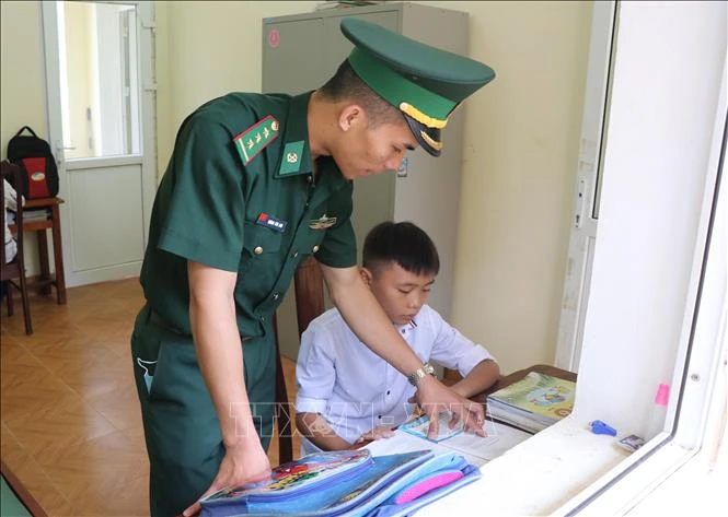 Chiến sĩ Đồn Biên phòng trực tiếp tiếp kèm cặp, hỗ trợ các cháu con nuôi của đơn vị học tập hằng ngày. Ảnh: Xuân Tiến – TTXVN 