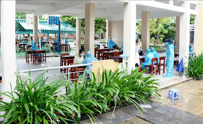 Việc lấy mẫu xét nghiệm trong cộng đồng được thực hiện đúng theo các quy định về giãn cách xã hội. Ảnh: TTXVN phát