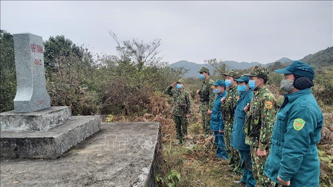 Cán bộ, chiến sĩ Đồn biên phòng Xín Cái và dân quân 2 xã Xín Cái, Thượng Phùng thực hiện nghi lễ chào cột mốc biên giới. Ảnh: Nguyễn Chiến-TTXVN
