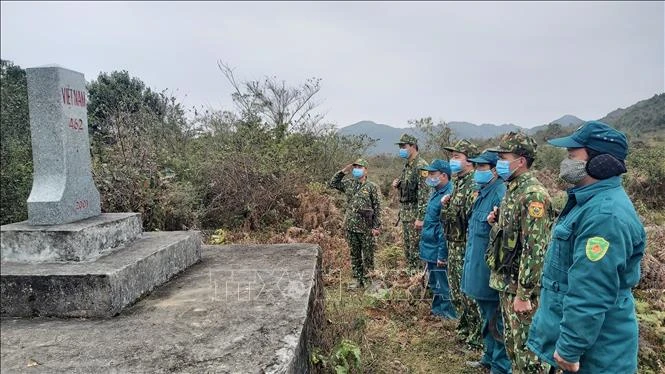 Cán bộ, chiến sĩ Đồn biên phòng Xín Cái và dân quân 2 xã Xín Cái, Thượng Phùng thực hiện nghi lễ chào cột mốc biên giới. Ảnh: Nguyễn Chiến-TTXVN