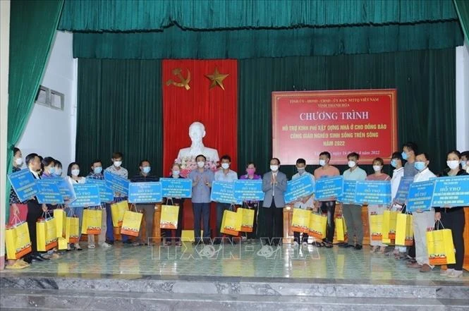 Bí thư Tỉnh ủy Thanh Hóa Đỗ Trọng Hưng và Giám mục Giáo phận Thanh Hóa Nguyễn Đức Cường trao tiền hỗ trợ cho các hộ đồng bào Công giáo sinh sống trên sông ở xã Định Tiến. Ảnh: Trịnh Duy Hưng - TTXVN 
