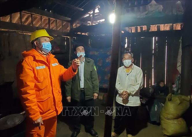 Công nhân Điện lực Mai Sơn, tỉnh Sơn La hướng dẫn người dân xã Chiềng Kheo sử dụng điện an toàn. Ảnh: TTXVN phát 