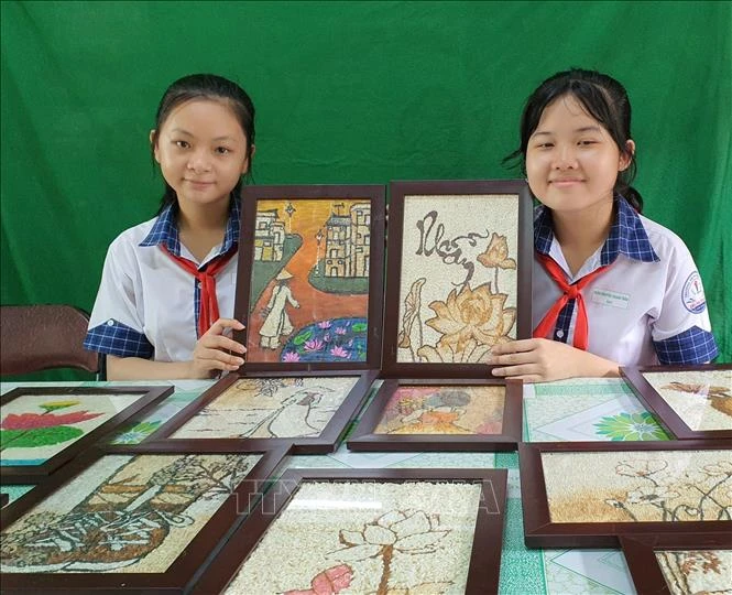 Hai chủ nhân của dự án bên các tác phẩm của mình. Ảnh: Ánh Tuyết - TTXVN
