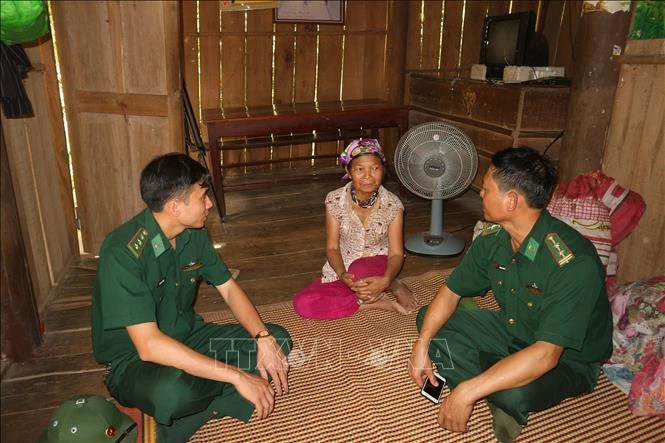 Cán bộ Đồn Biên phòng Bản Giàng thường xuyên đến nhà các hộ dân dạy bà con về phát triển kinh tế, cách phòng bệnh. Ảnh: Hoàng Ngà - TTXVN