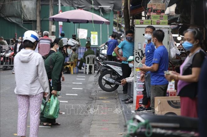 Người dân giữ khoảng cách khi mua hàng tại khu mua sắm hàng thiết yếu trên phố Nguyễn Thiện Thuật, quận Hoàn Kiếm (ảnh chụp sáng 26/7). Ảnh: Minh Quyết - TTXVN 