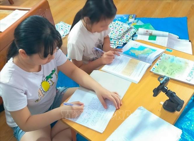 Hầu hết sách giáo khoa từ các nhà trường đã được chuyển tới học sinh trước ngày khai giảng nên học sinh yên tâm đủ sách để học trực tuyến tại nhà. Ảnh: TTXVN phát 