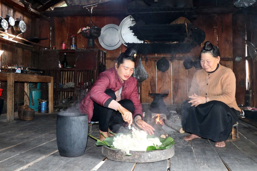 Xôi được đồ từ gạo nếp tan Mường Và bằng chõ gỗ trên bếp củi. Ảnh: Hữu Quyết – TTXVN