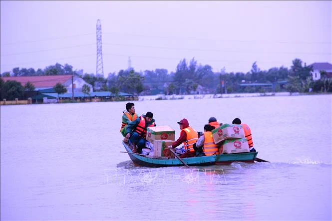 Vận chuyển hàng cứu trợ bằng xuồng máy vào các vùng ngập sâu. Ảnh: Hoàng Ngà - TTXVN
