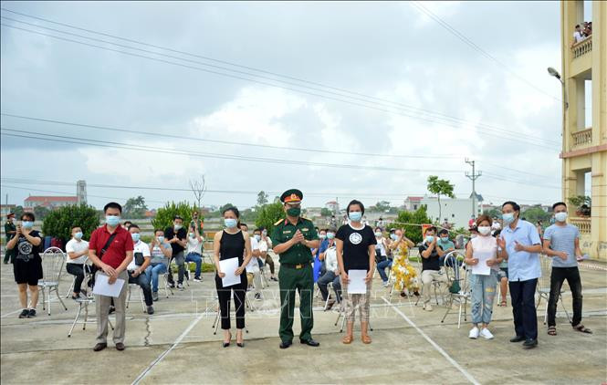 Trao giấy chứng nhận hoàn thành thời gian cách ly cho các công dân. Ảnh: TTXVN phát