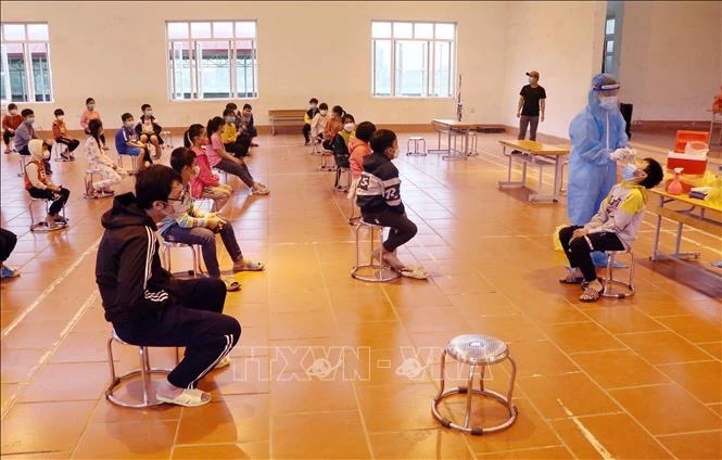 Nhân viên tế Phú Thọ tổ chức lấy mẫu xét nghiệm lần 3 cho học sinh Trường tiểu học Bạch Hạc. Ảnh: Trung Kiên – TTXVN 