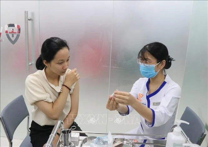 Nhân viên Trung tâm VNVC Buôn Ma Thuột tư vấn về vắc xin bạch hầu cho người dân. Ảnh: Tuấn Anh - TTXVN