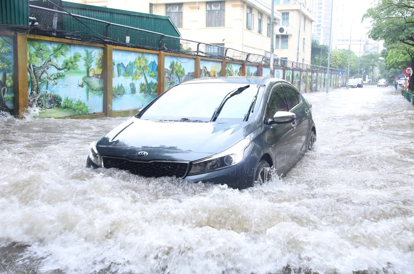 Mưa bão gây ngập úng ảnh hưởng đến việc di chuyển của người dân. Ảnh: Hoàng Hiếu - TTXVN 