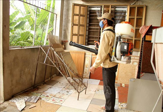 Cán bộ Trung tâm y tế phun hóa chất diệt muỗi . Ảnh: Văn Tý-TTXVN