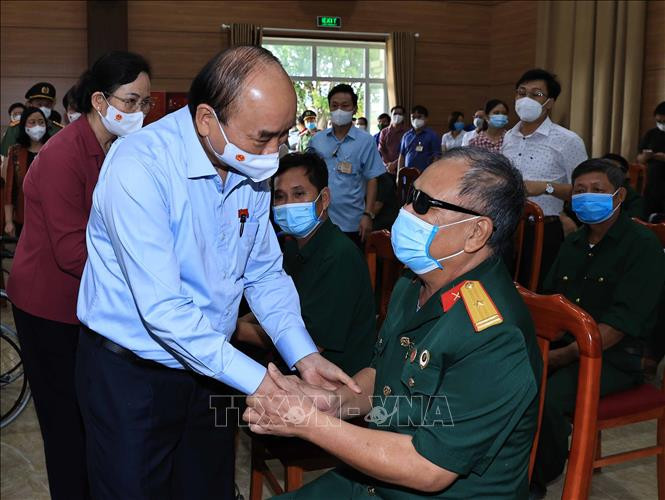 Chủ tịch nước Nguyễn Xuân Phúc thăm hỏi và tặng quà cho thương bệnh binh tại Trung tâm nuôi dưỡng bệnh binh nặng và Điều dưỡng Người có công tỉnh Hà Nam. Ảnh: Thống Nhất -TTXVN