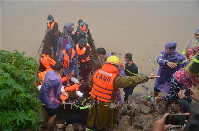 Lực lượng Cảnh sát Phòng cháy chữa cháy và cứu nạn cứu hộ - Công an tỉnh Gia Lai cứu hộ 14 hộ dân đến nơi an toàn. Ảnh: Quang Thái- TTXVN 