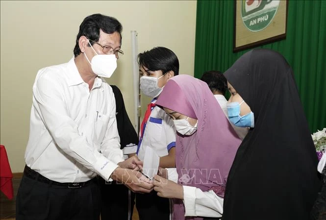 Phó Chủ tịch UBND tỉnh AN Giang Lê Văn Phước trao học bổng cho các em học sinh dân tộc Chăm trên địa bàn huyện An Phú. Ảnh: Công Mạo-TTXVN
