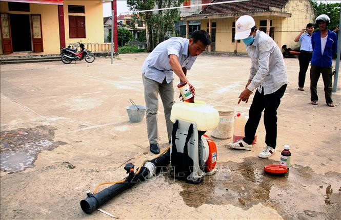 Cán bộ Trung tâm y tế huyện Quảng Ninh (Quảng Bình) pha thuốc phun hóa chất diệt muỗi tại xã Võ Ninh. Ảnh: Văn Tý-TTXVN