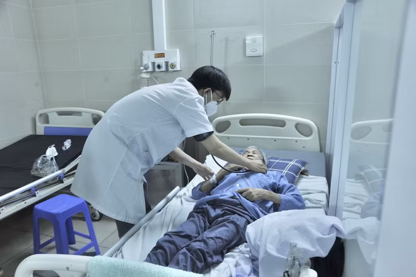 Bác sỹ thăm khám sức khỏe bệnh nhân COVID-19 tại Bệnh viện Thanh Nhàn. Ảnh: TTXVN phát 
