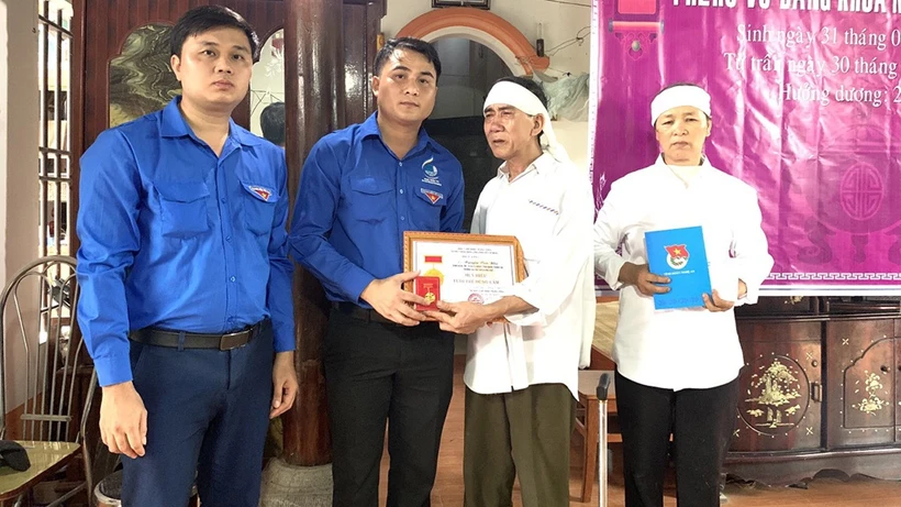 Người thân sinh viên Nguyễn Văn Nhã nhận Huy Hiệu Tuổi trẻ dũng cảm của T.Ư Đoàn truy tặng nam sinh dũng cảm. Ảnh: thanhnien.vn