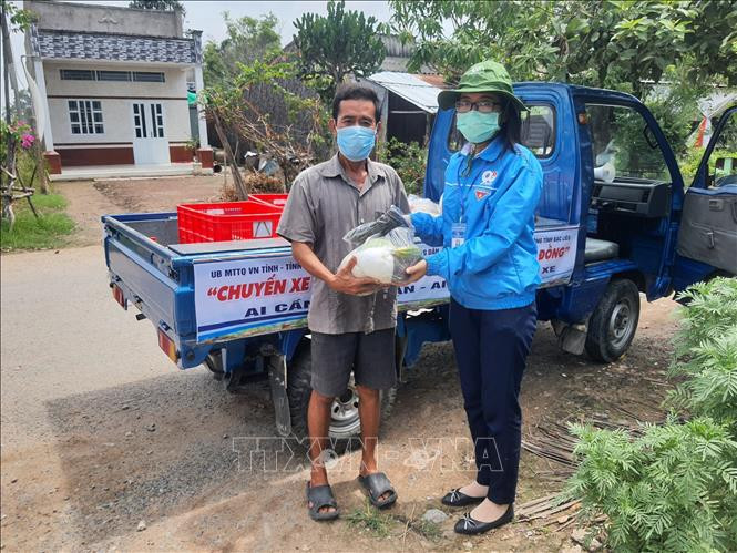 Trao các phần cho người dân có hoàn cảnh khó khăn. Ảnh: Nhật Bình - TTXVN. 