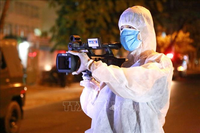 Quay phim Viết Đức (Truyền hình Thông tấn Vnews) tác nghiệp trong khu vực bị phong tỏa. Ảnh: Quốc Dũng – TTXVN