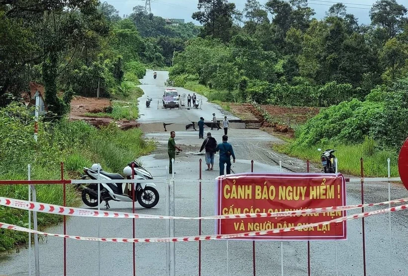 Lực lượng chức năng phong tỏa đoạn đường bị sụt lún. Ảnh: TTXVN phát 