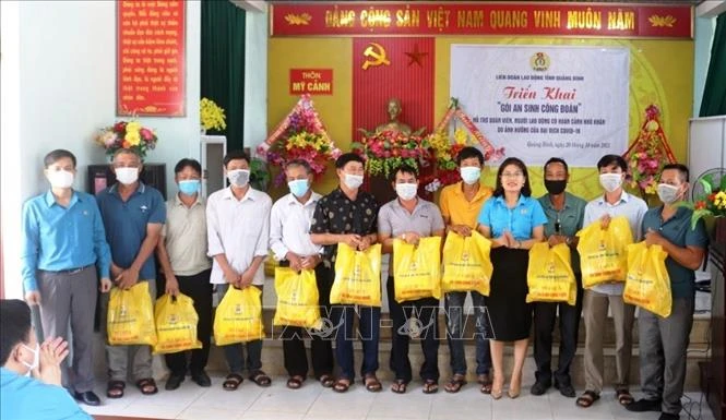 Các đoàn viên, người lao động trên địa bàn tỉnh Quảng Bình phấn khởi khi nhận các túi quà hỗ trợ từ "Gói an sinh Công đoàn". Ảnh: TTXVN phát 