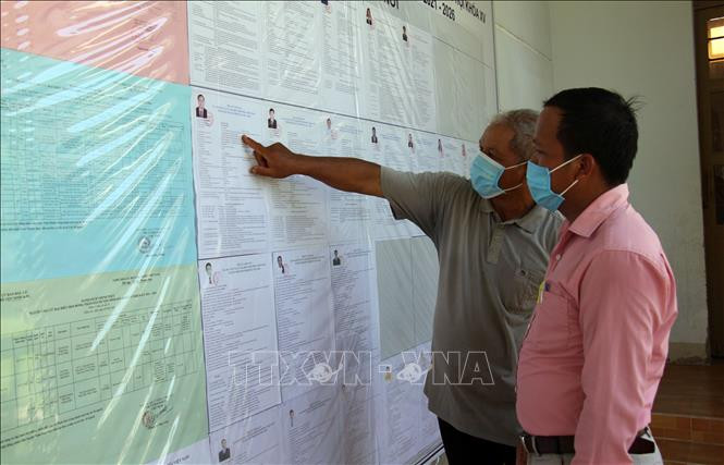 Cử tri xã Phước Trung, huyện Bác Ái tìm hiểu tiểu sử của các ứng cử viên đại biểu Quốc hội và HĐND các cấp tại tổ bầu cử số 5 ở địa phương. Ảnh: Công Thử - TTXVN