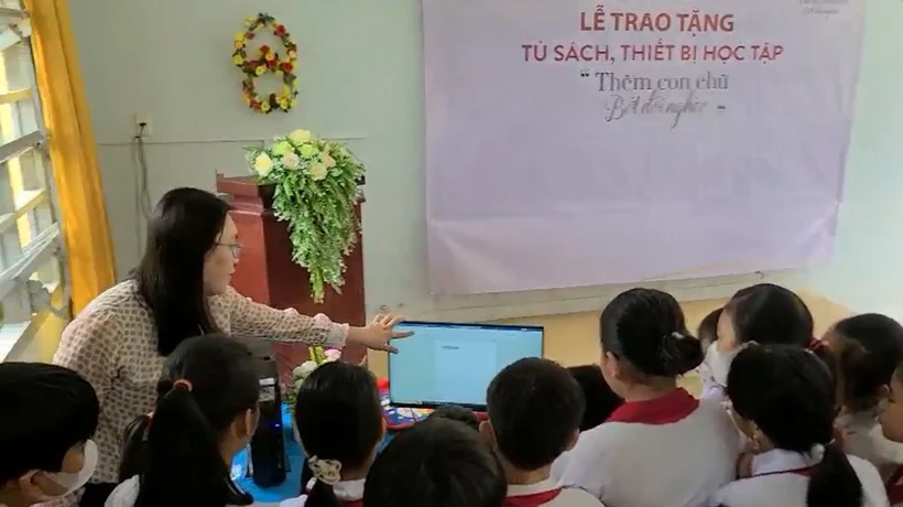 Cô và trò Trường Tiểu học Bình Xuân 1 (thị xã Gò Công) sử dụng máy vi tính vừa được trao tặng từ Chương trình của Agribank Tiền Giang. Ảnh: Hữu Chí – TTXVN 