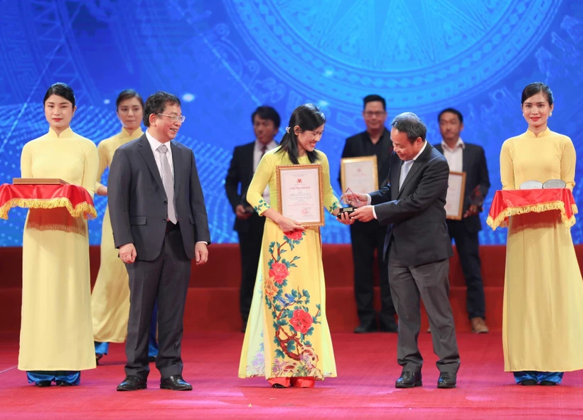 Phó Tổng Giám đốc Thông tấn xã Việt Nam Nguyễn Tuấn Hùng và Phó Tổng Biên tập báo Nhân Dân Đinh Như Hoan trao giải Ba cho các tác giả đạt giải. Ảnh: Thanh Tùng - TTXVN 