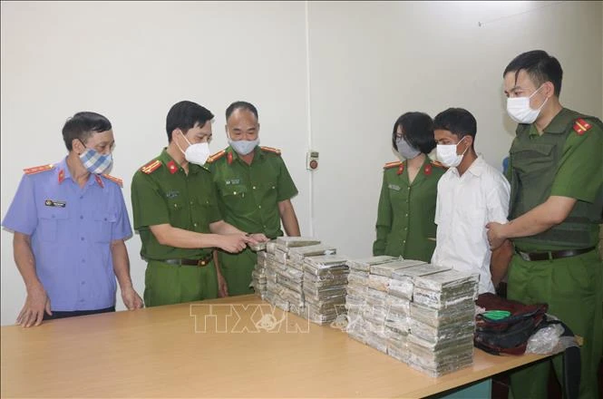 Thượng tá Nguyễn Ngọc Thắng (thứ 2 từ trái sang phải), Phó Giám đốc Công an tỉnh Điện Biên đang kiểm tra tang vật vụ án trong chuyên án 121V. Ảnh: TTXVN phát 