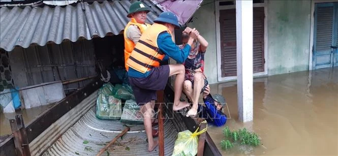 Lực lượng chức năng giúp người dân di dời đến nơi an toàn. Ảnh: TTXVN phát