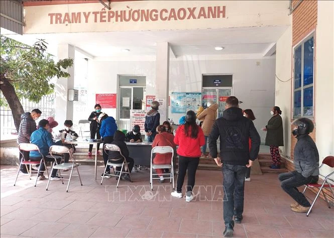 Lượng người dân là F1, F0 đến trạm y tế khá đông cùng thời điểm nhưng nhân viên y tế chỉ có 1 người tiếp đón, sàng lọc, hướng dẫn, dẫn đến tình trạng quá tải, không có người để tư vấn. Ảnh: Thanh Vân-TTXVN 