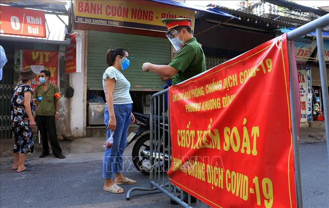 Kiểm tra thẻ đi chợ của người dân tại chốt kiểm soát chợ Khương Đình . Ảnh: Tuấn Anh - TTXVN 