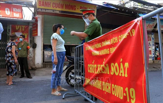 Kiểm tra thẻ đi chợ của người dân tại chốt kiểm soát chợ Khương Đình . Ảnh: Tuấn Anh - TTXVN 