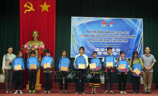 Đại diện Quỹ học bổng Vừa A Dính trao học bổng và đồ dùng học tập cho các em học sinh có hoàn cảnh khó khăn. Ảnh: Khoa Chương – TTXVN