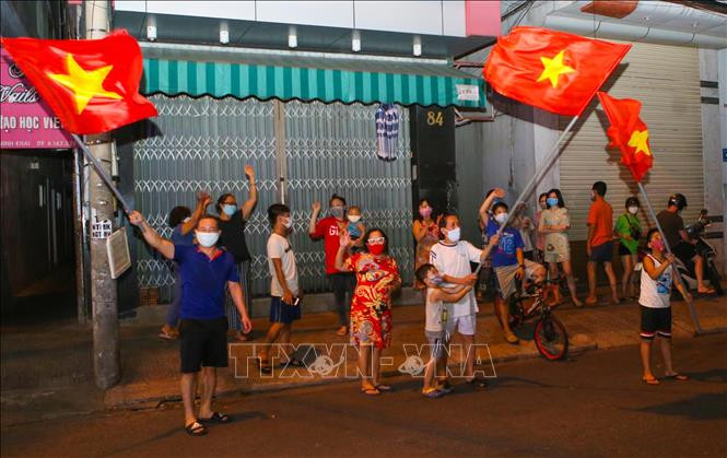 Người dân ở trên tuyến đường Nguyễn Thị Minh Khai vui mừng sau khi hoàn thành cách ly 14 ngày trong khu vực phong tỏa. Ảnh: Trần Lê Lâm - TTXVN