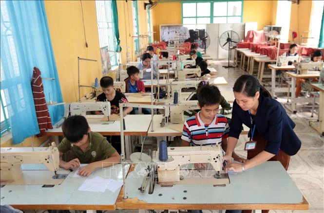 Dạy nghề may công nghiệp cho học sinh tại trường Phục hồi chức năng và dạy nghề cho người khuyết tật huyện Khoái Châu. Ảnh: Phạm Kiên - TTXVN