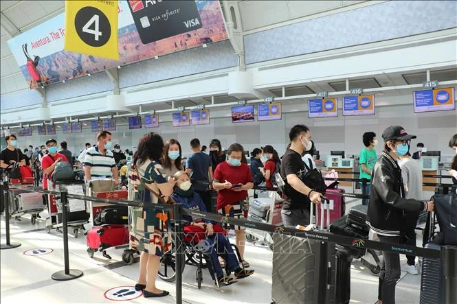 Công dân Việt Nam làm thủ tục lên máy bay về nước tại sân bay thành phố Toronto. Ảnh: Quang Thịnh - TTXVN
