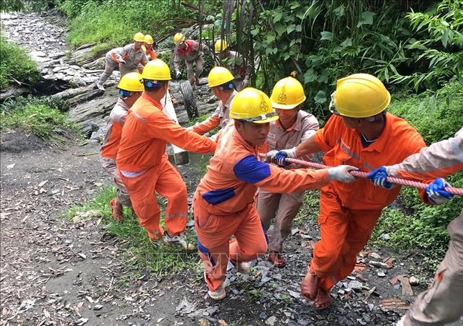 Công nhân Công ty Điện lực Hà Giang thay thế cột điện bị gãy đổ do mưa lũ. Ảnh: Ngọc Hà - TTXVN 