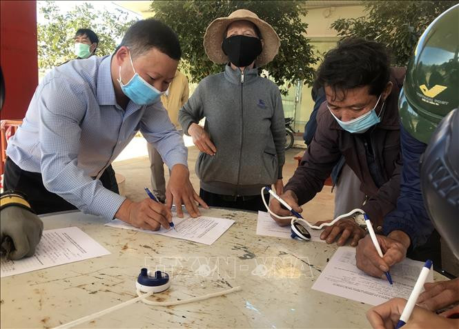 Người dân tiến hành khai báo y tế tại chốt kiểm soát dịch COVID-19. Ảnh: Khoa Chương - TTXVN