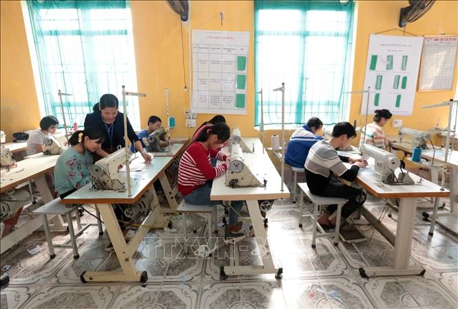 Dạy nghề May công nghiệp cho học sinh tại Trường Phục hồi chức năng và Dạy nghề cho người khuyết tật huyện Khoái Châu. Ảnh: Phạm Kiên - TTXVN