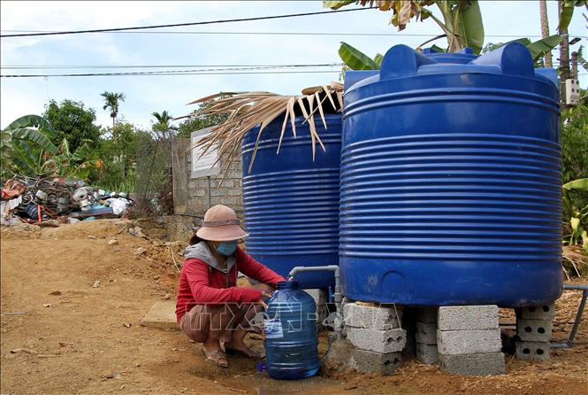 Người dân xã Mai Hóa huyện Tuyên Hóa, tỉnh Quảng Bình phấn khởi khi được sử dụng nước miễn phí tại một điểm cấp nước. Ảnh: Văn Tý-TTXVN 