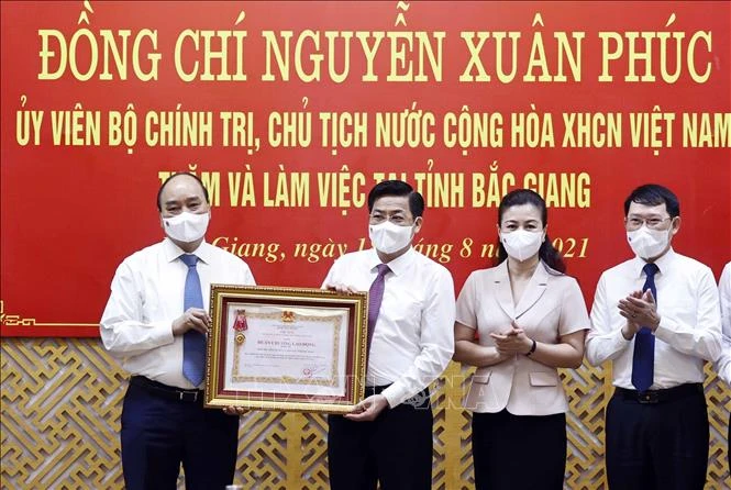 Chủ tịch nước Nguyễn Xuân Phúc trao Huân chương Lao đông hạng Ba cho Đảng bộ, chính quyền và nhân dân tỉnh Bắc Giang. Ảnh: Thống Nhất - TTXVN 