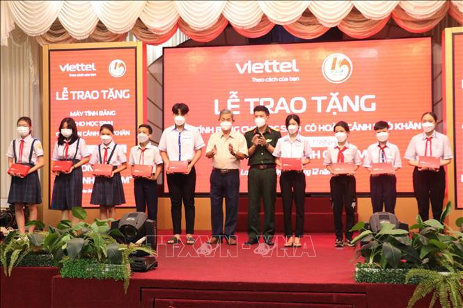 Đại diện Tập đoàn Viettel và Hội khuyến học tỉnh Long An trao máy tính bảng cho các em học sinh có hoàn cảnh khó khăn. Ảnh: Bùi Giang - TTXVN 