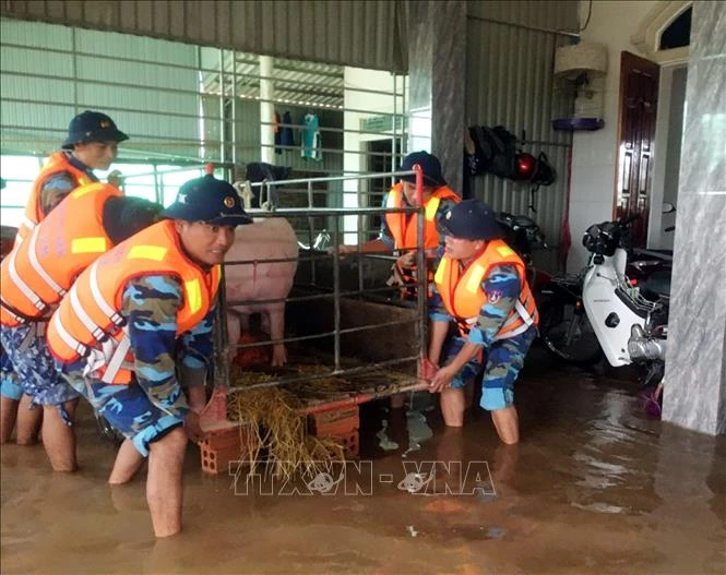 Cán bộ, chiến sĩ Hải đội 102 giúp bà con dọn dẹp nhà cửa khi nước rút. Ảnh: TTXVN