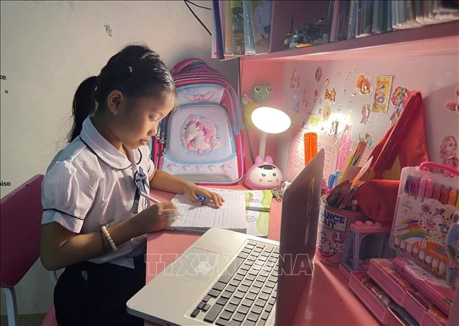 Học sinh lớp 2 trường tiểu học Hàm Nghi (thành phố Đông Hà) tỉnh Quảng Trị học online tại nhà vào buổi tối. Ảnh: Thanh Thủy - TTXVN 