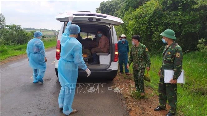 Bộ đội biên phòng Đắk Nông bàn giao các đối tượng vượt biên trái phép cho cơ sở y tế để đưa đi cách ly. Ảnh: TTXVN phát